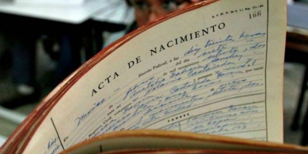 Un libro está abierto en una página que dice acta de nacimiento
