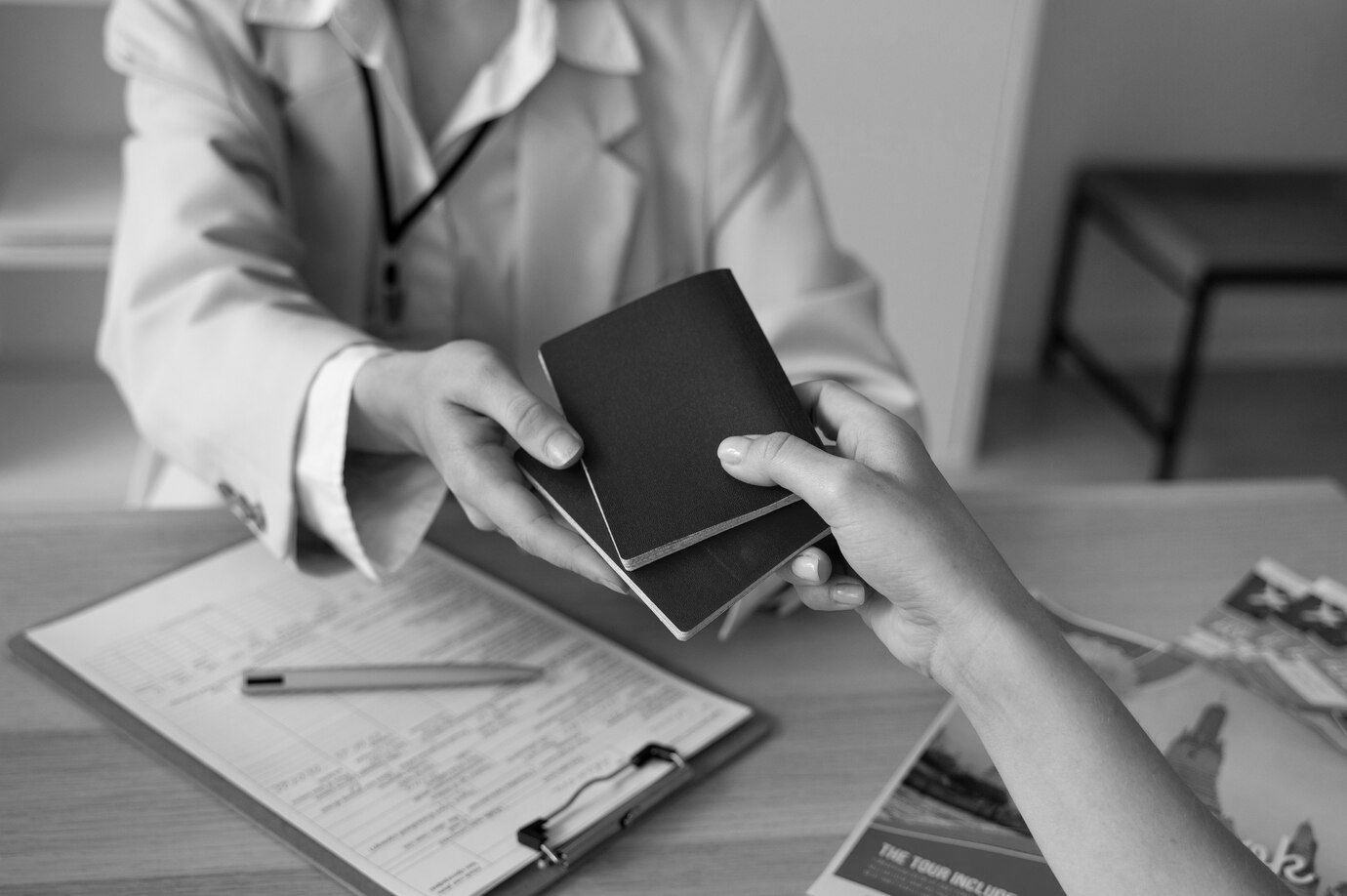 Un médico le da un pasaporte a un paciente en una foto en blanco y negro.