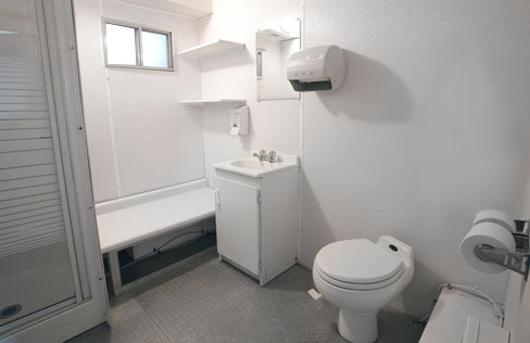 A bathroom with a toilet , sink , and shower. Toilets trailer. Brazeau Sanitation