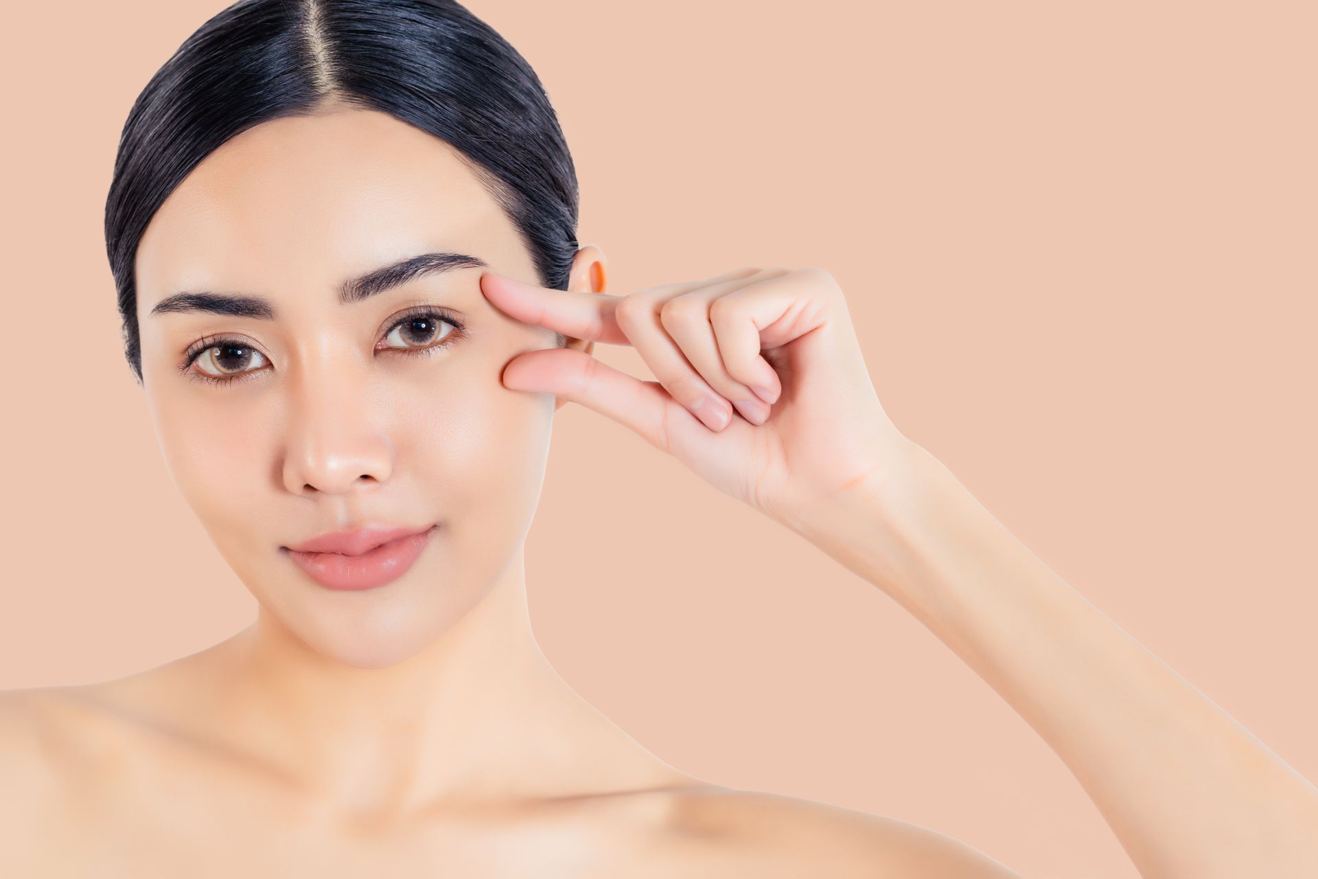 A woman is touching her eye with her finger.