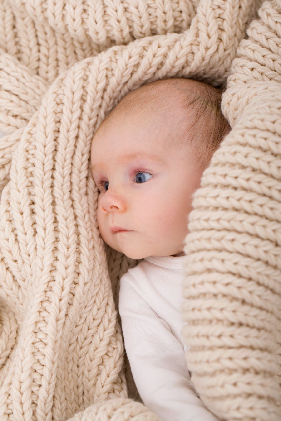 nordwestnord fotografie babyfotoshooting baby in strickpullover eingewickelt