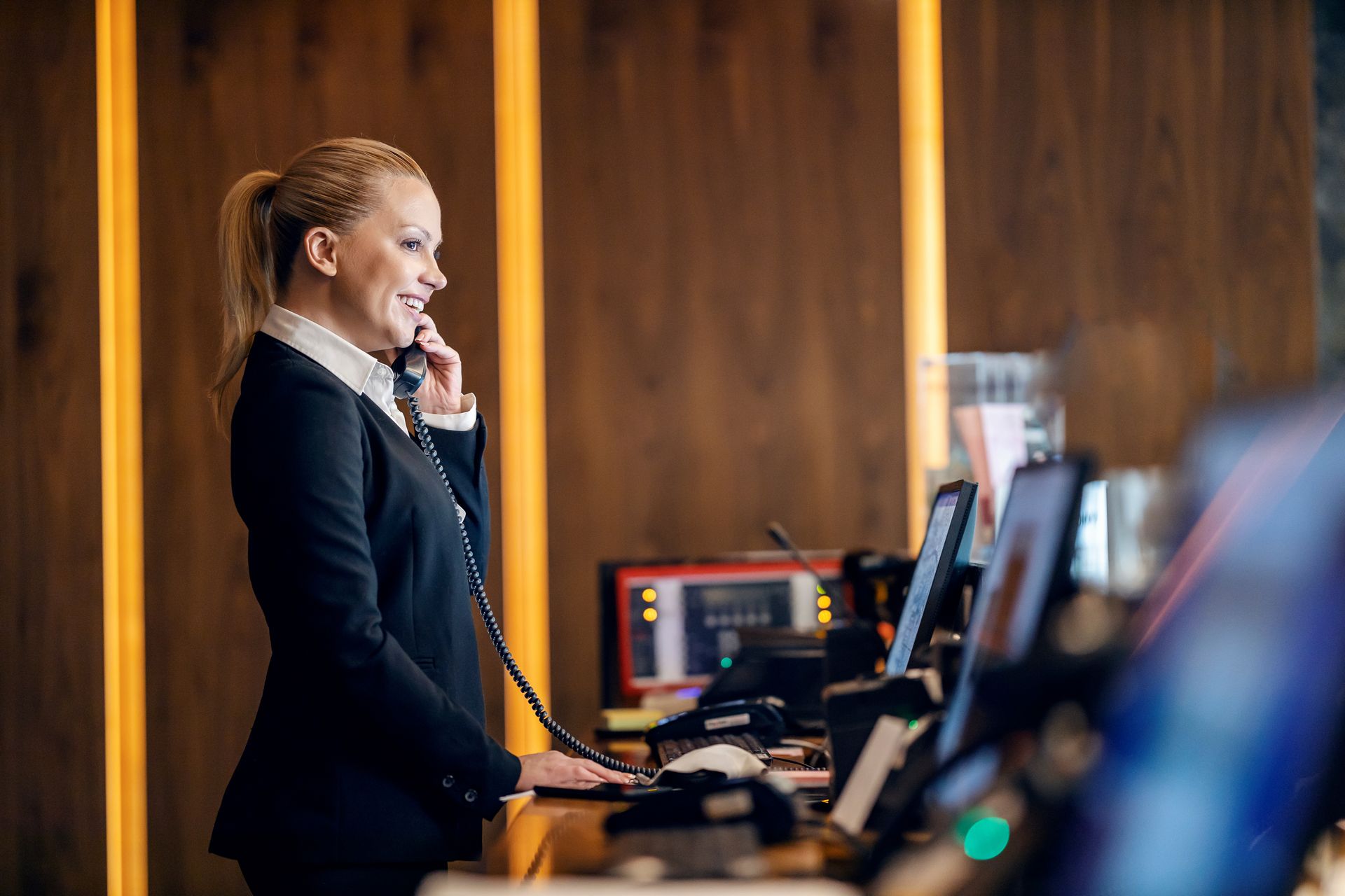 A woman is talking on a phone in a hotel lobby.
