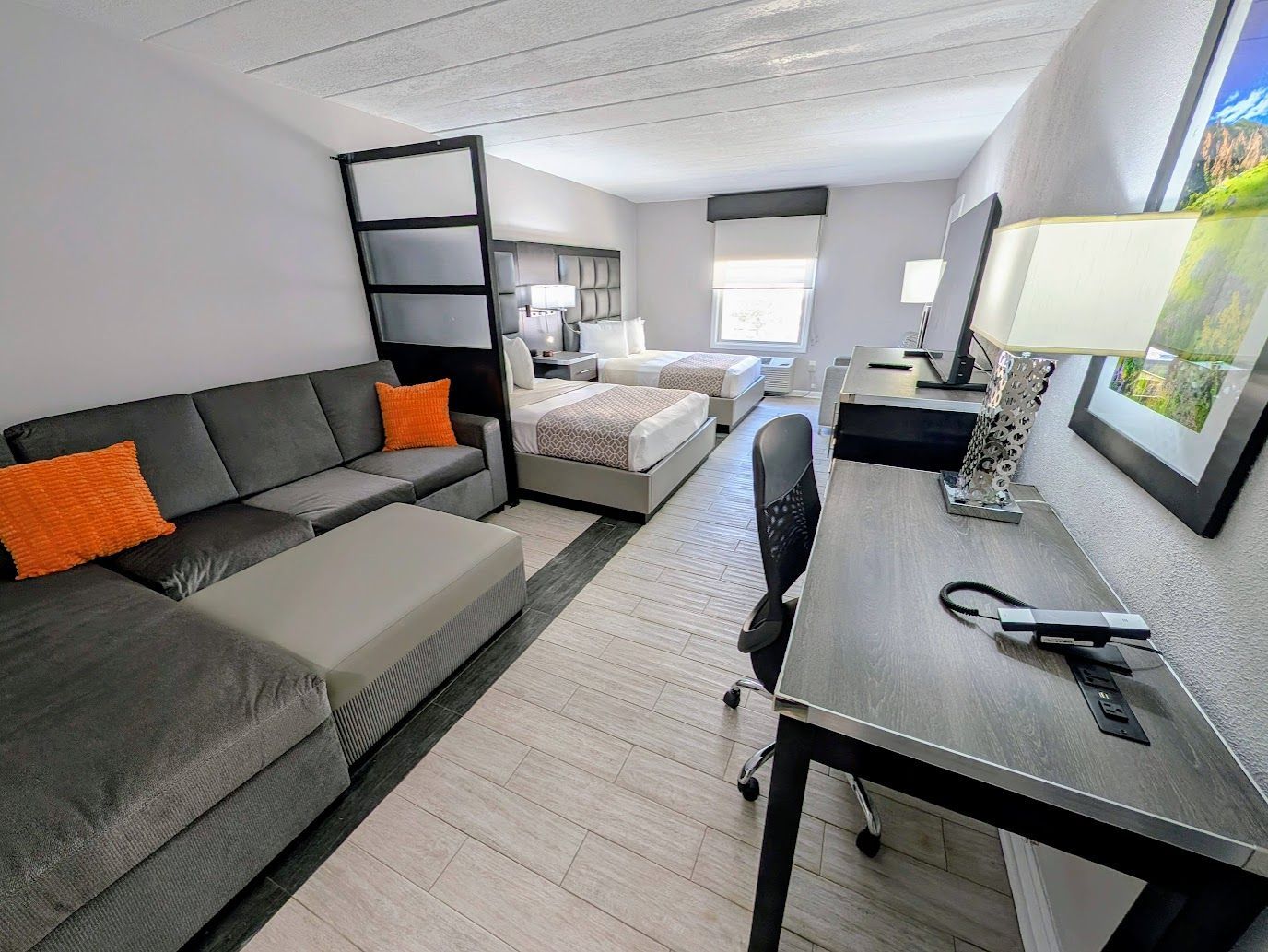 A hotel room with two beds and a couch.