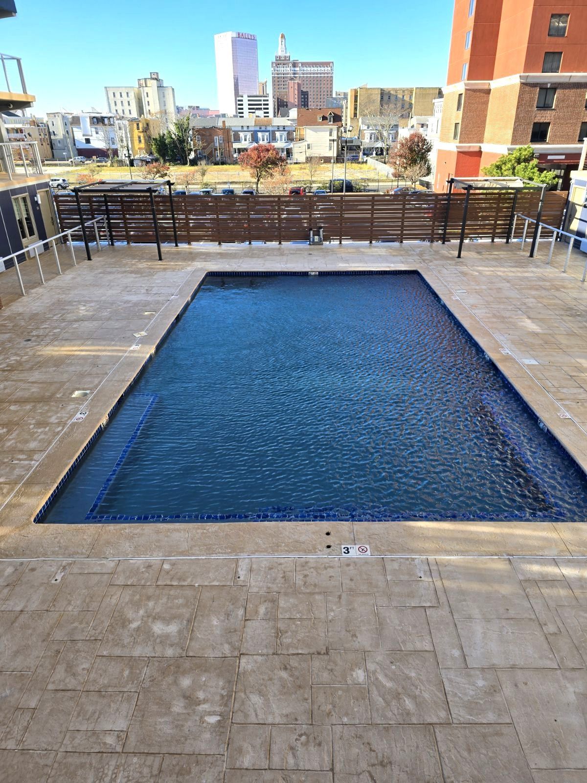 A large swimming pool with a city in the background