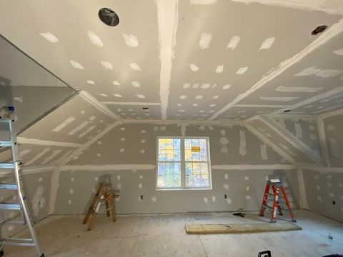A room with a ladder and a window is being remodeled.