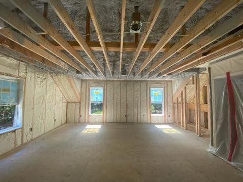 An empty room with a wooden ceiling and a lot of windows.