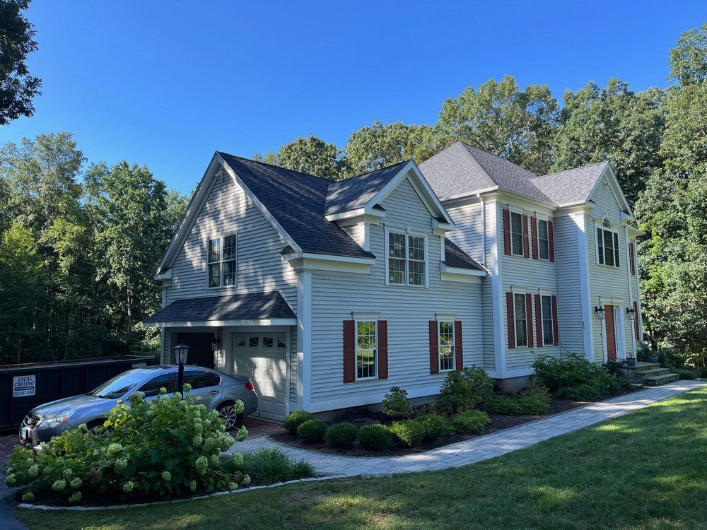 A large white house with a car parked in front of it.