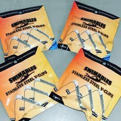 Four bags of swimables stainless steel v-clips are sitting on top of each other on a table.