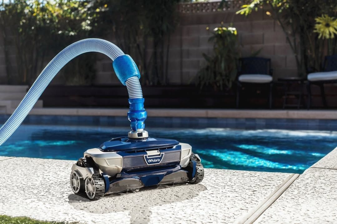 A robotic vacuum cleaner is sitting on the edge of a swimming pool.