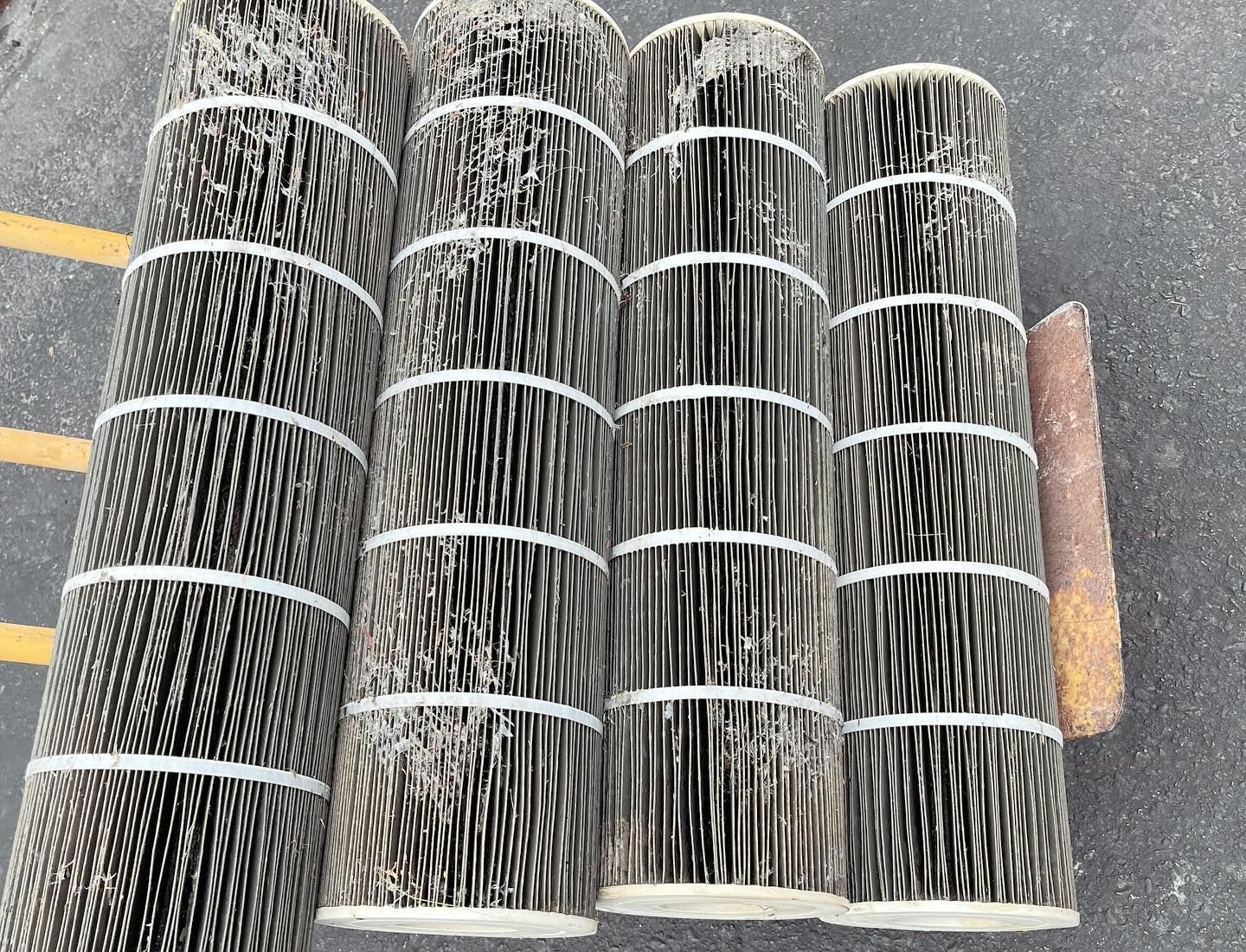 A bunch of brushes are stacked on top of each other on the ground.