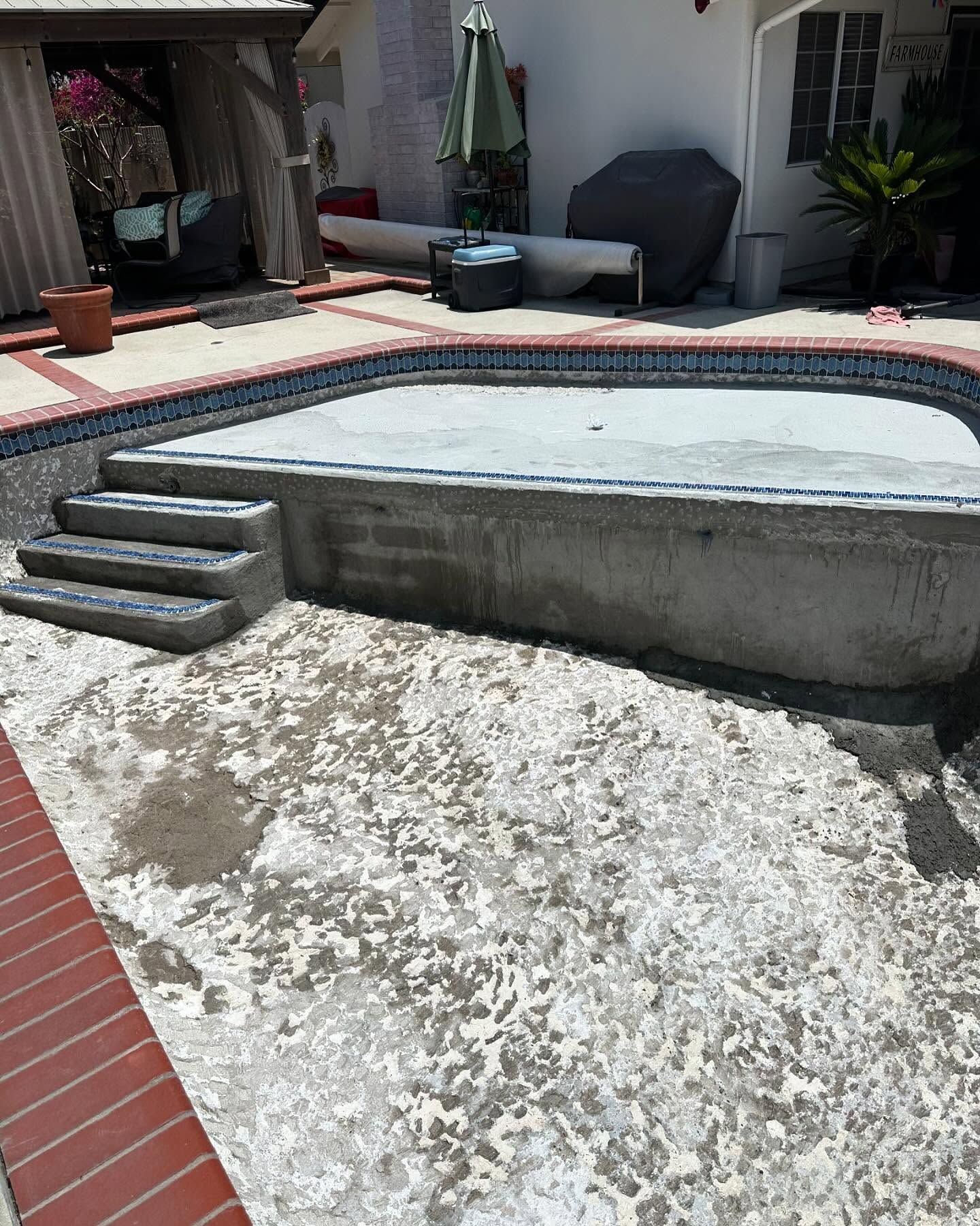 A swimming pool is being built in a backyard.