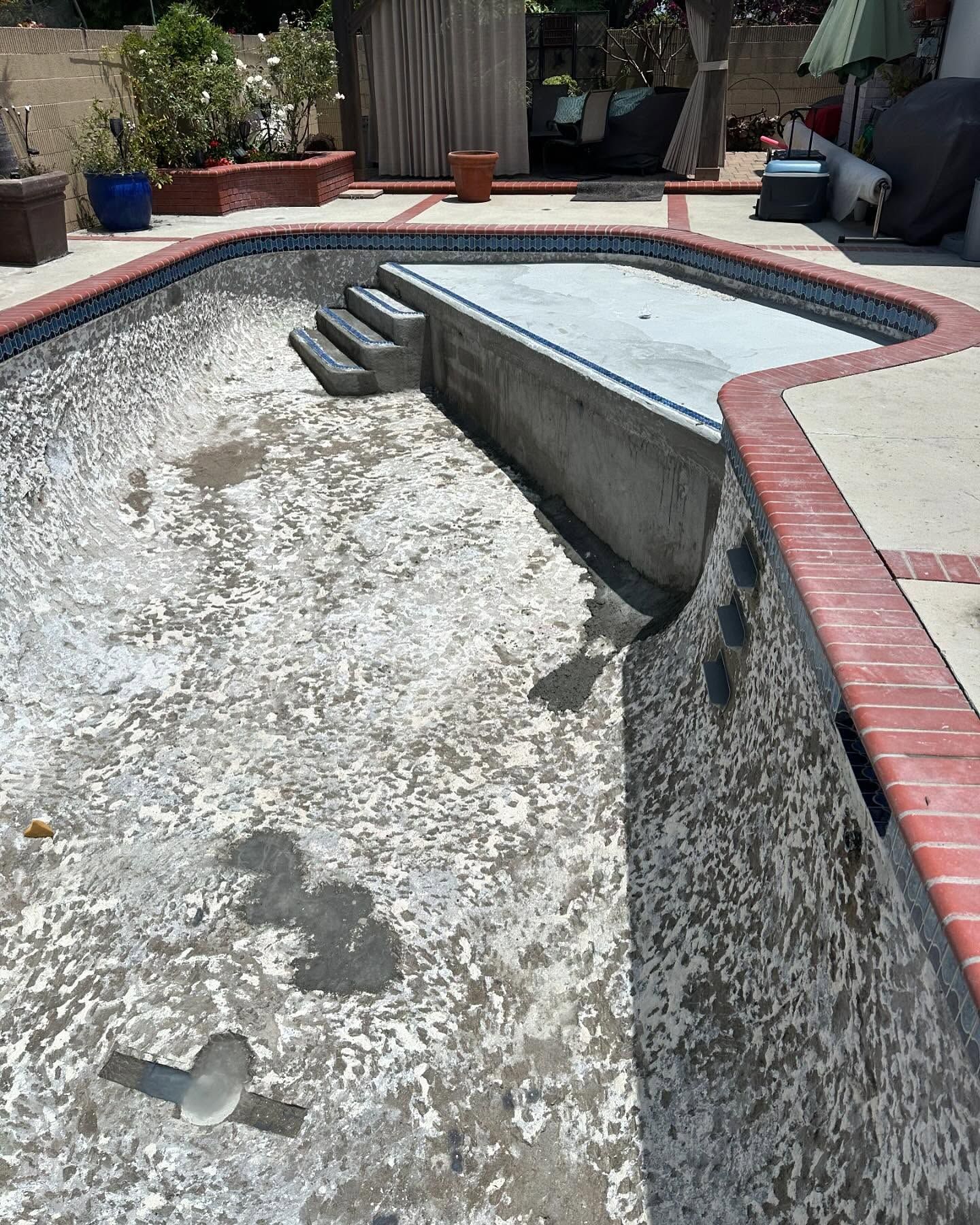 An empty swimming pool with stairs leading to it