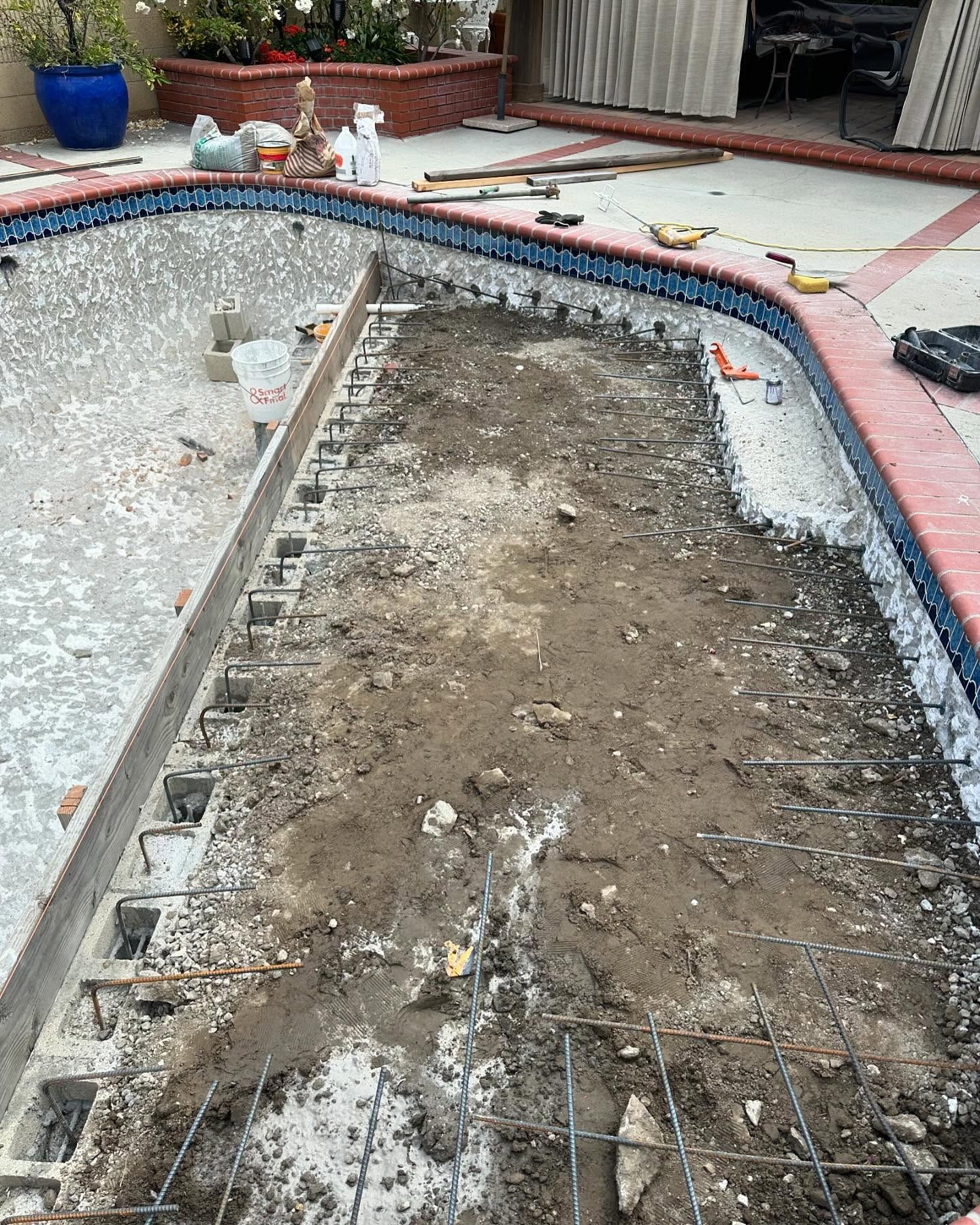 A swimming pool is being remodeled in a backyard.