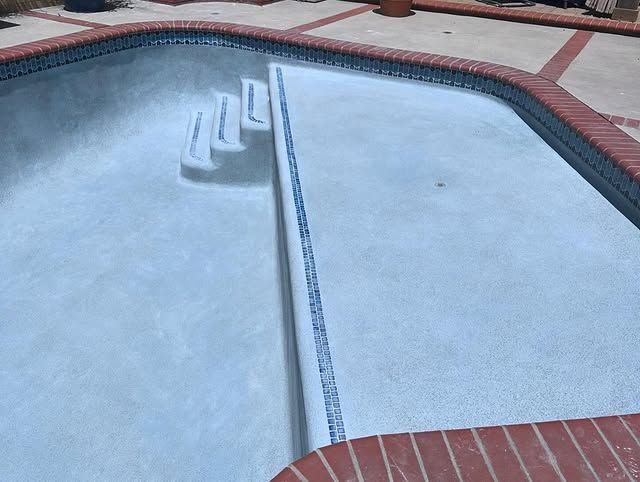 A swimming pool with a brick border and steps