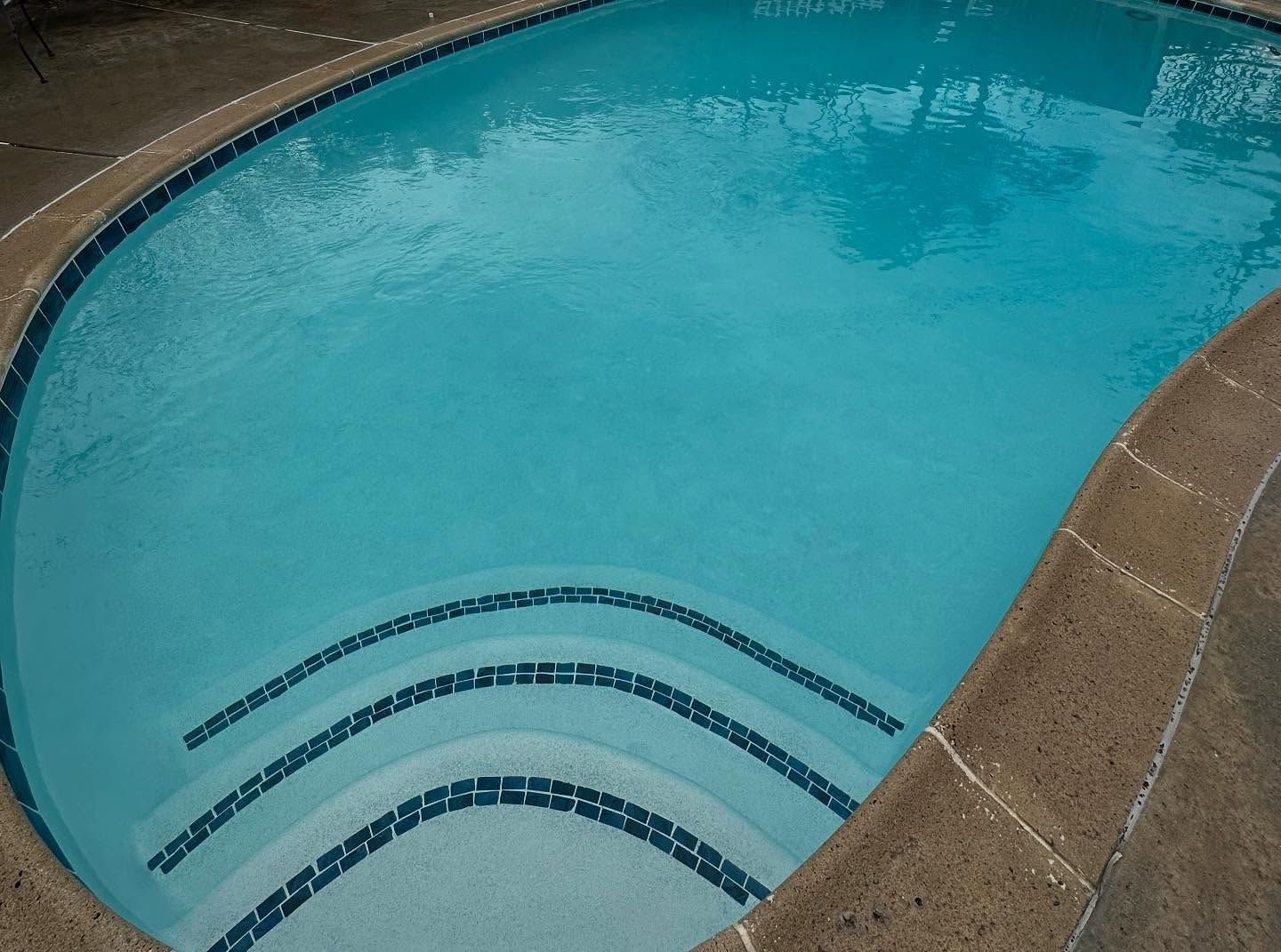 A large swimming pool with stairs leading up to it