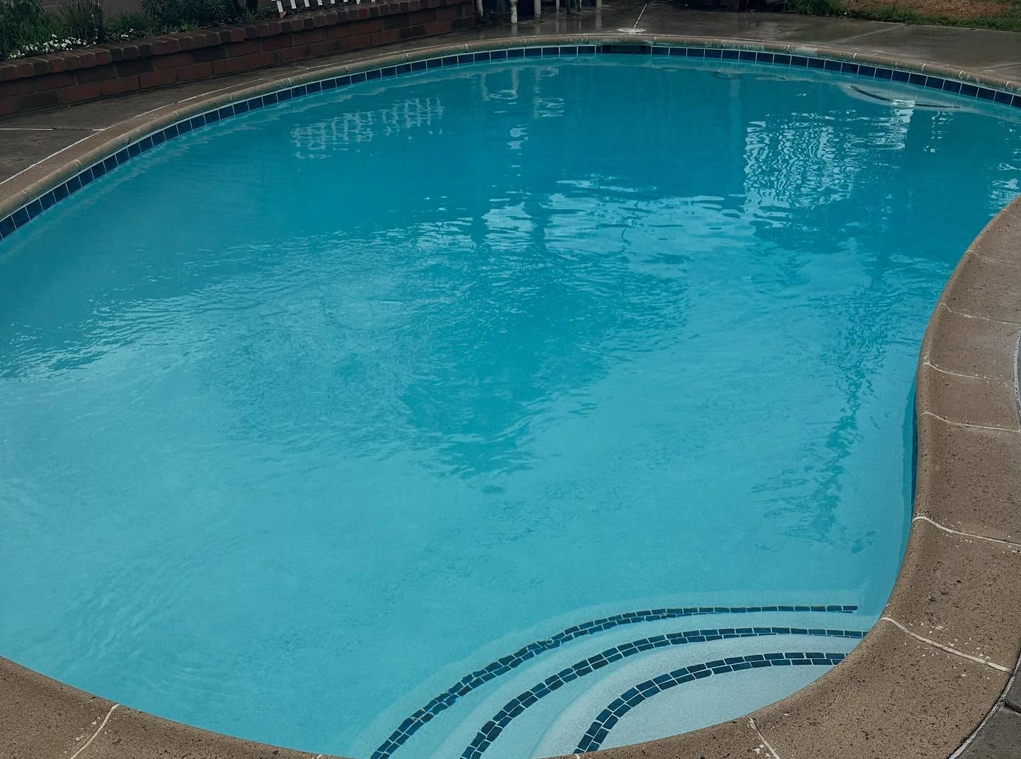 A large swimming pool with stairs leading to it