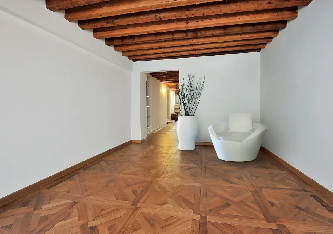 Una stanza vuota con un pavimento in legno e una sedia bianca