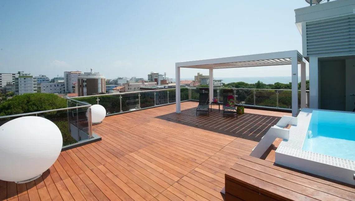 Una terrazza panoramica con piscina e pergolato.
