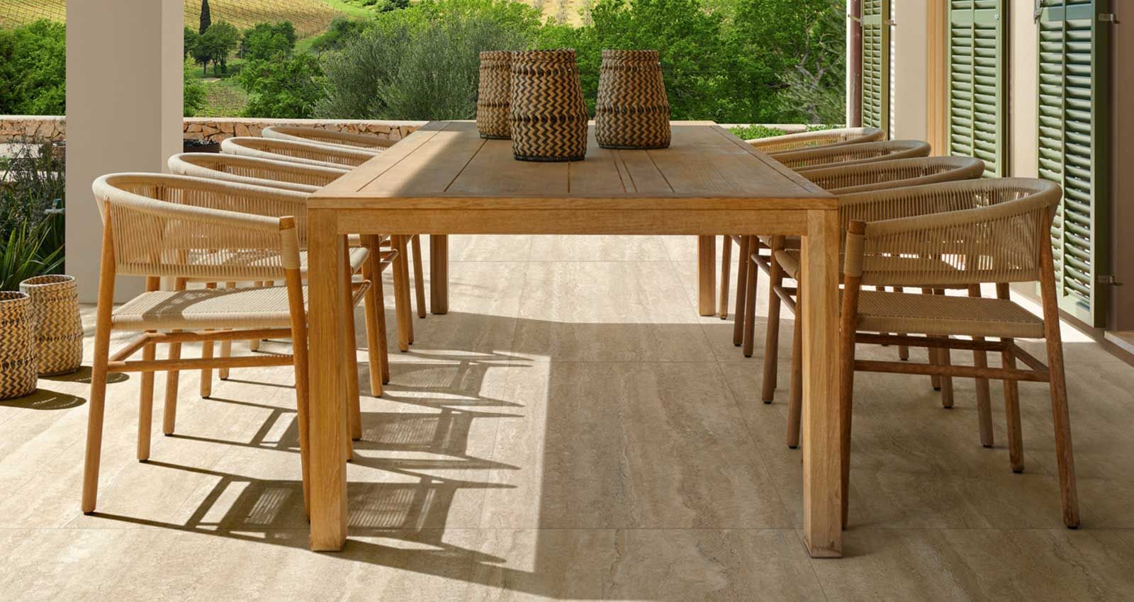 Un tavolo e delle sedie di legno sono sistemati nel patio.