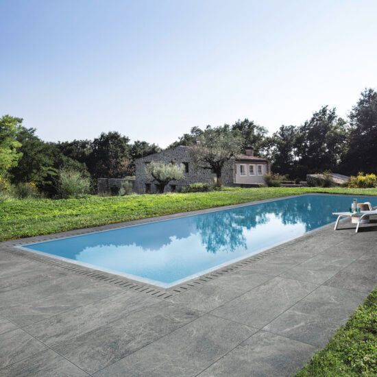 Una grande piscina con una casa sullo sfondo