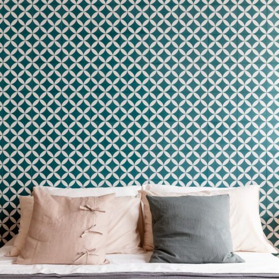 Un letto con cuscini e una parete decorata dietro