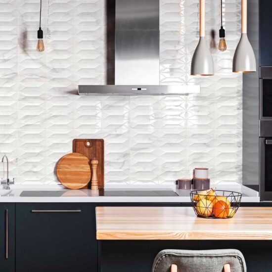 Una cucina con fornelli, forno, un tagliere, una ciotola di frutta e una sedia.