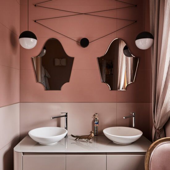 Un bagno con due lavandini e due specchi sul muro