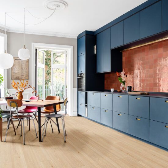 Una cucina con mobili blu, tavolo e sedie