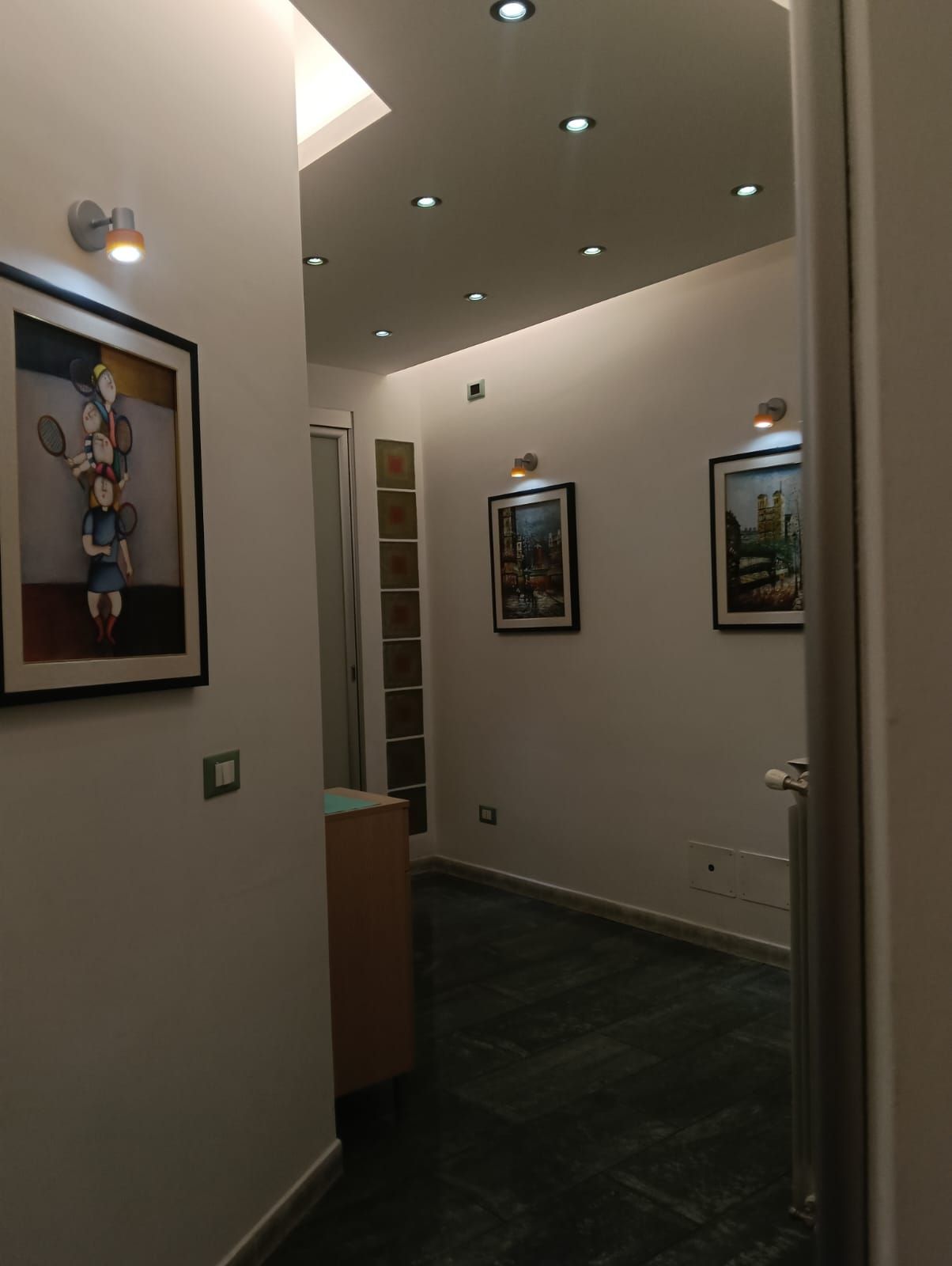 Un corridoio con alcuni quadri sul muro