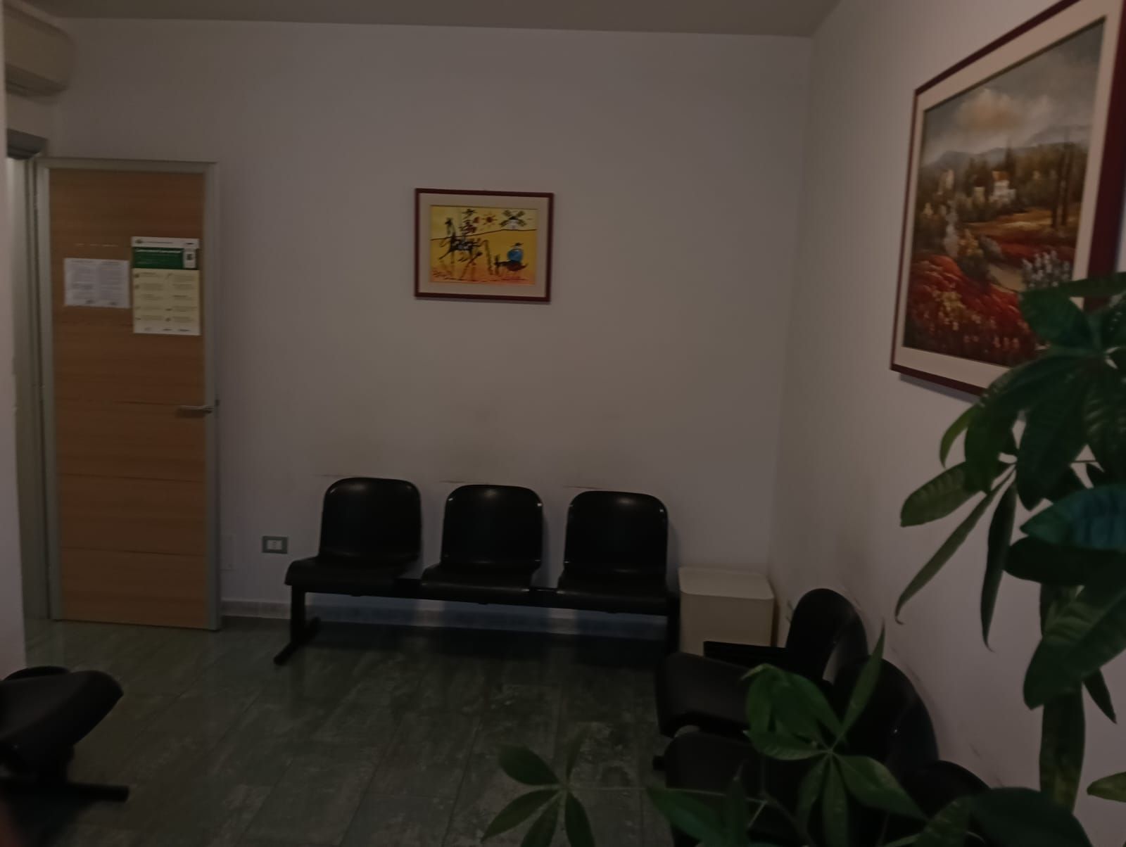 Una sala d'attesa con sedie e un quadro sul muro