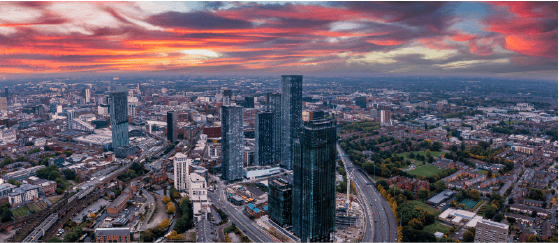 An aerial view of a city with a sunset in the background.