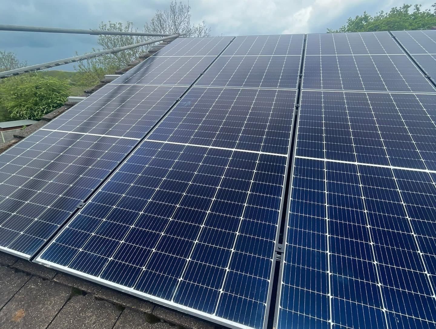 A row of solar panels are sitting on top of a roof.