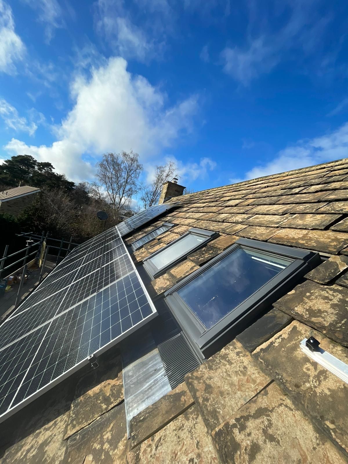 A roof with a skylight and solar panels on it.