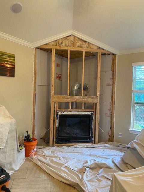 Fireplace under construction, framed with exposed wood studs; drywall removed.