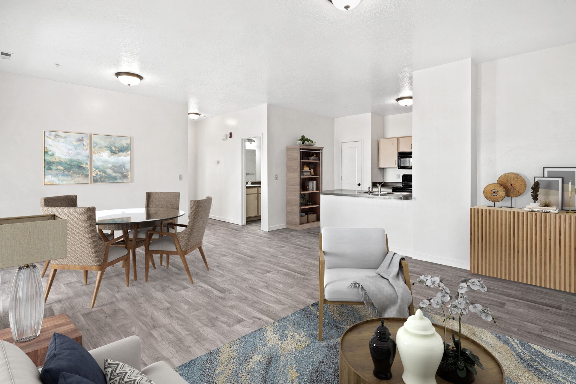 Open-concept living room and dining area with a visible kitchen and modern furnishings.