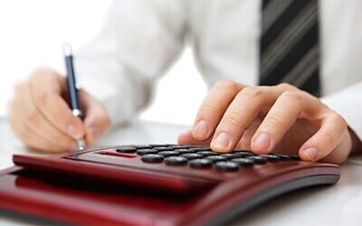 Man Working with Pen and Calculator — Accountant in Woodstock, IL