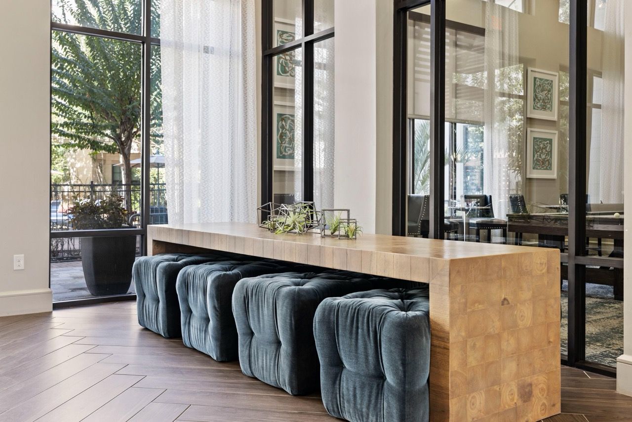 Bright lobby with a long wooden reception desk and blue tufted benches.