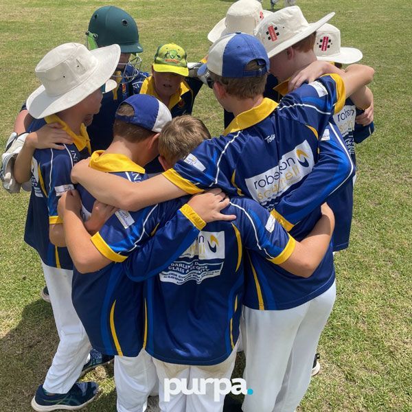a group of junior cricket players huddled together