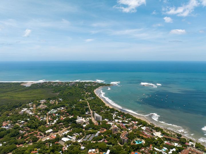 an aerial view of a small town next to the ocean in Costa Rica