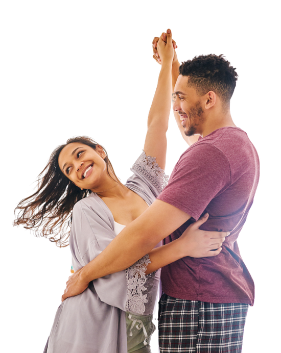 Couple dancing joyfully; woman smiling, arm raised, man's arms around her waist.