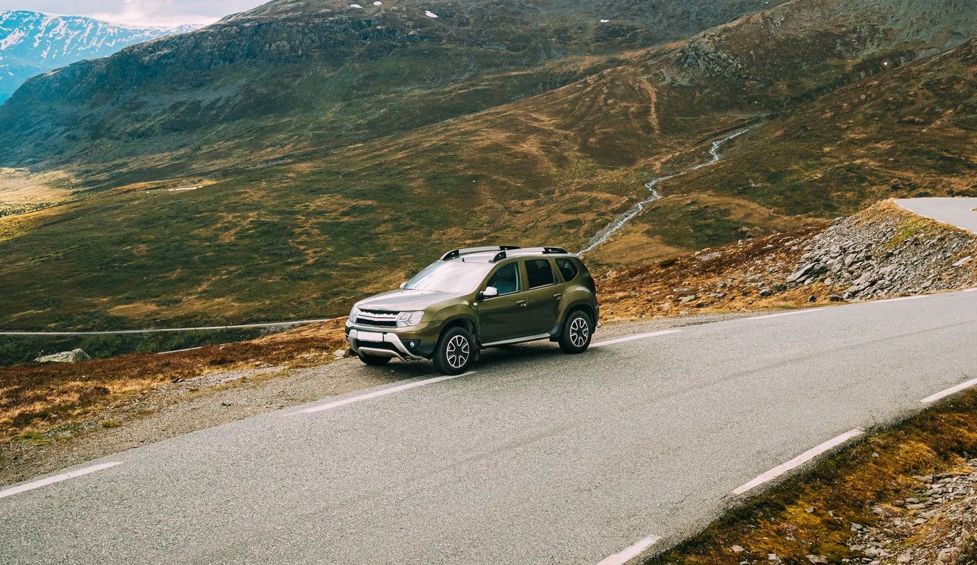 A car is driving down a mountain road.