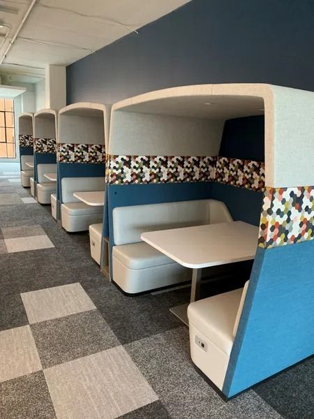 A row of booths with tables and benches in a hallway