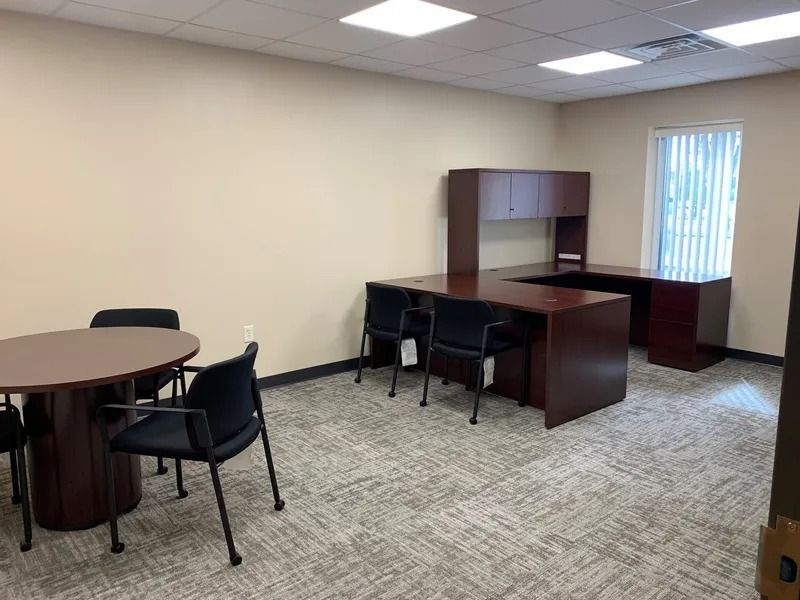 A small office with a table and chairs in it.