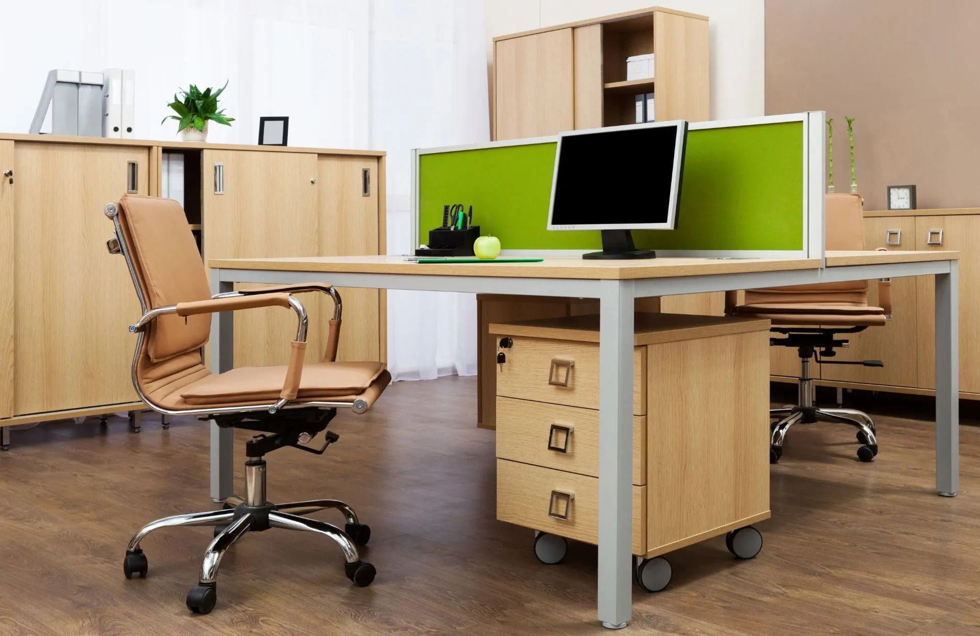 A desk with a computer and a chair in an office