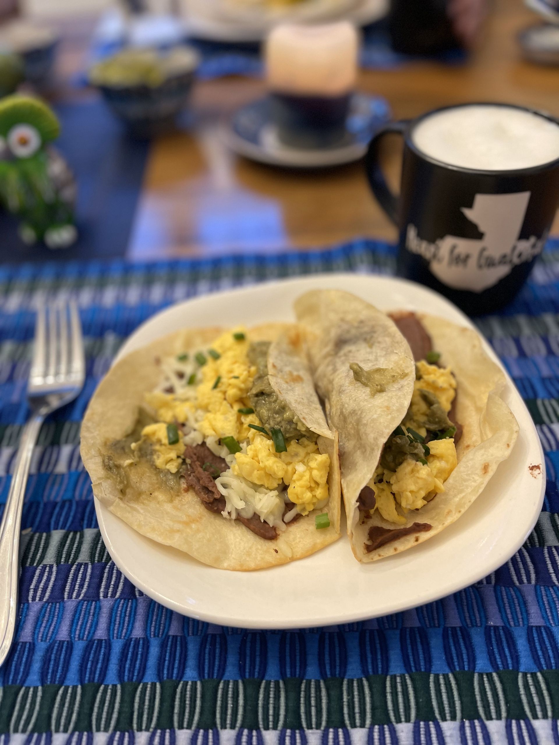 A white plate topped with two tacos on a table