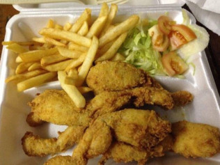 Fried frog legs, fries, and salad on a styrofoam plate.