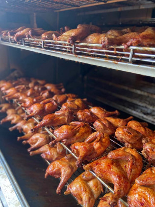 Roasted chickens on metal racks inside an oven.