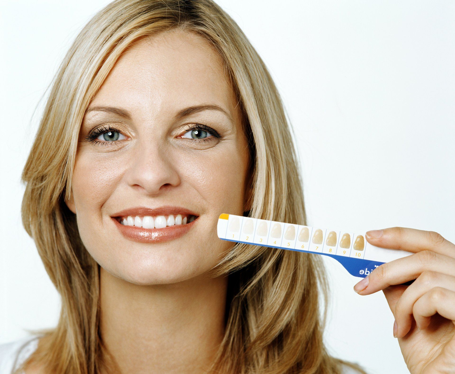 A lady holding teeth whitening spatula