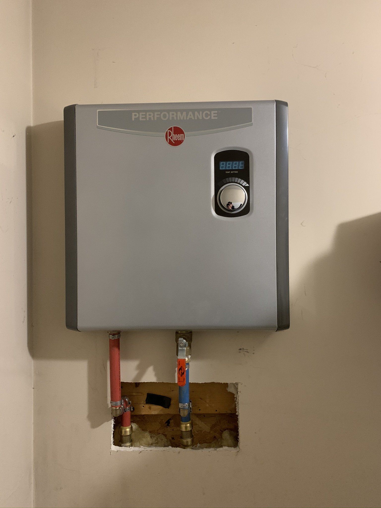 A performance water heater is mounted on a wall