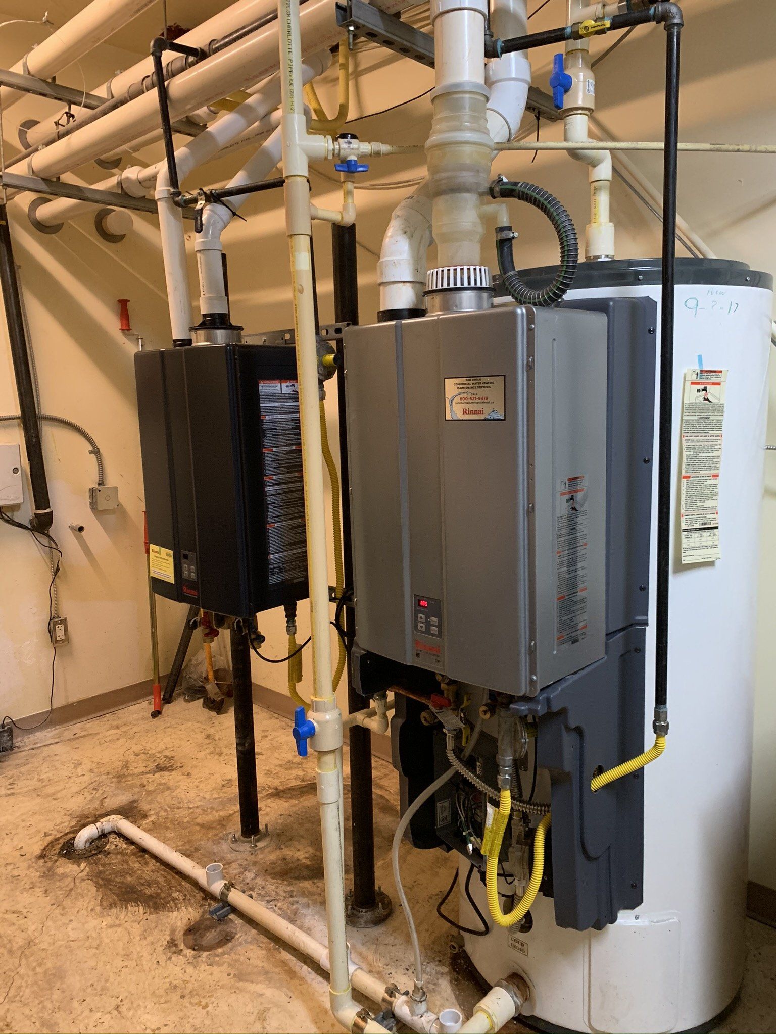 Two water heaters are sitting next to each other in a room.